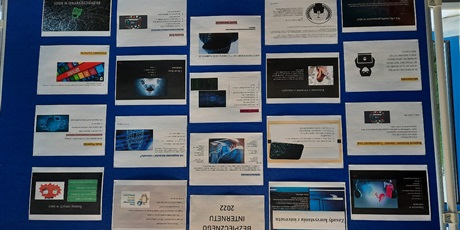 Powiększ grafikę: Na tablicy znajdującej się przy wejściu główny wiszą slajdy prezentacji wykonane przez uczniów, dotyczące zasad bezpiecznego korzystania z Internetu.