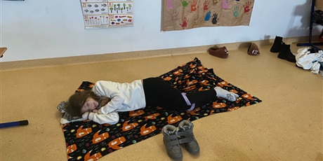 Powiększ grafikę: Uczniowie klasy 3e ubrani w kolorowe piżamy odpoczywają na materacach.  