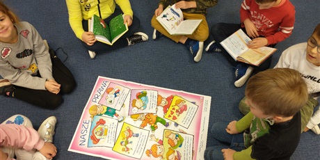 Powiększ grafikę: Dzieci ze świetlicy klas 3 zapoznają się z plakatem i książkami o prawach dziecka.