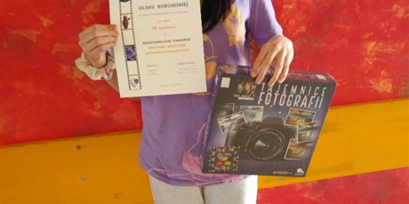 Powiększ grafikę: Oliwia pokazuje dyplom i nagrodę za udział w konkursie. 