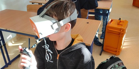 Powiększ grafikę: Uczeń testuje gogle VR.