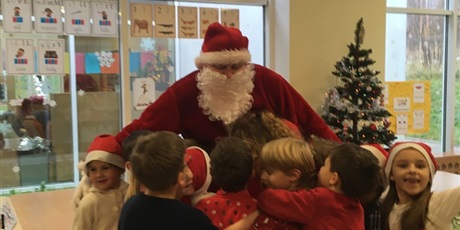 Powiększ grafikę: Dzieci przytulają się do Św. Mikołaja.
