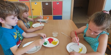 Powiększ grafikę: Dzieci malują farbami jabłka do eksperymentu.