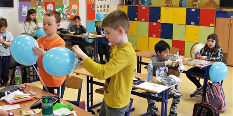 Powiększ grafikę: Uczniowie klasy 1 przyklejają kontynenty na balony.