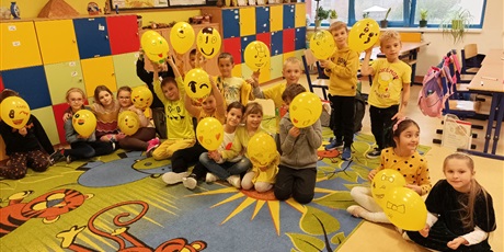 Powiększ grafikę: Uczniowie podrzucający balony.