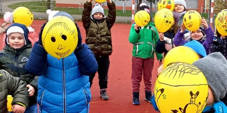 Powiększ grafikę: Zabawa żółtymi balonami na boisku szkolnym.