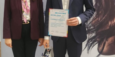 Powiększ grafikę: Zwycięzca gali prezentuje dyplom.