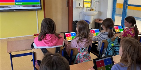 Powiększ grafikę: Uczennice z klasy 2c i 2d patrzą na tablicę interaktywną i zastanawiają się nad poprawną odpowiedzią.
