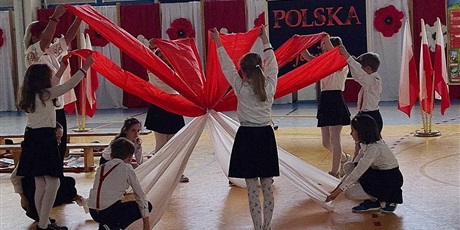 Powiększ grafikę: Klasa 2A prezentuje przy muzyce układ ruchowy z materiałami w kolorach polskiej flagi.