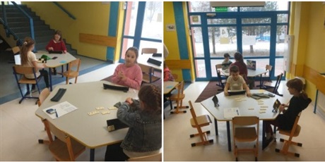 Powiększ grafikę: Uczniowie grają w grę Rummikub przy stolikach.