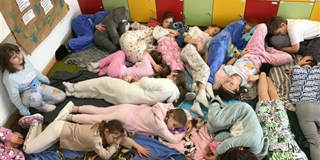 Powiększ grafikę: Dzieci odpoczywają na dywanie.