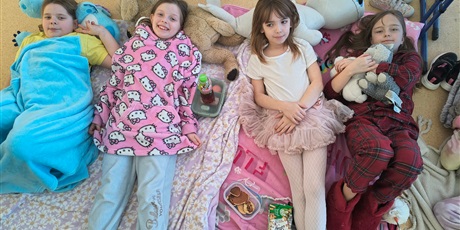 Powiększ grafikę: Dziewczynki leżą na kocykach.