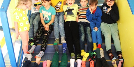Powiększ grafikę: Uczniowie klasy 1a w kolorowych skarpetkach na szkolnych schodach 