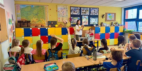 Powiększ grafikę: Na fotografii prowadzący tłumaczy dzieciom, czym są odpady niebezpieczne i jak należy z nimi postępować.