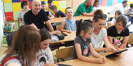 Uczniowie klasy 2 A uczą Rodziców obsługi szkolnych iPadów.