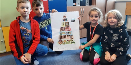 Powiększ grafikę: Uczniowie prezentują wykonaną Piramidę Zdrowego Zywienia i Aktywności Fizycznej. 