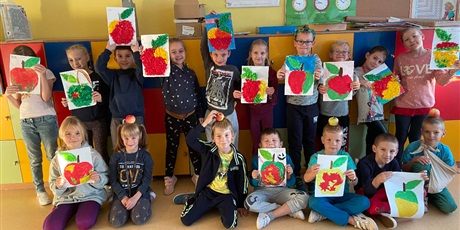 Powiększ grafikę: Zdjęcie grupowe uczniów prezentujących wykonane prace plastyczne jabłek. 