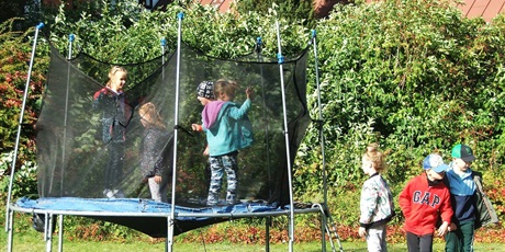 Powiększ grafikę: Dzieci bawią się na trampolinie. 