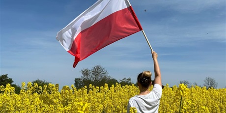 Powiększ grafikę: Dziewczyna trzymająca flagę Polski w polu rzepaku.