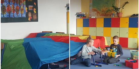Powiększ grafikę: Zdjęcie przedstawia dzieci podczas zabawy, dzieci zbudowały namiot z dużej chusty animacyjnej.