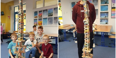 Powiększ grafikę: Zdjęcie przedstawia dzieci, które zbudowały wysoką wieżę z drewnianych klocków oraz nauczyciela - pana Dominika, który porównuje wysokość wieży do swojego wzrostu.