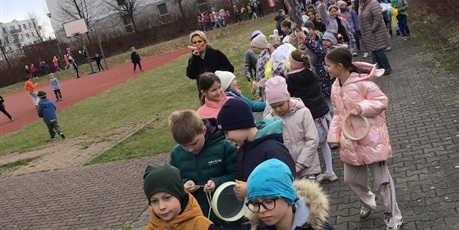 Powiększ grafikę: Uczniowie klas 1-3 okrążają szkołę żegnając zimę. 